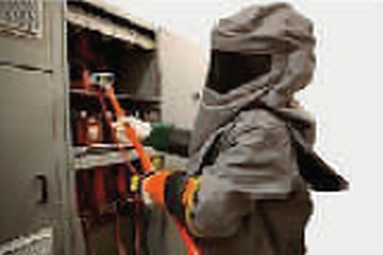 Engineer in an arc-flash suit working on a high-voltage panel