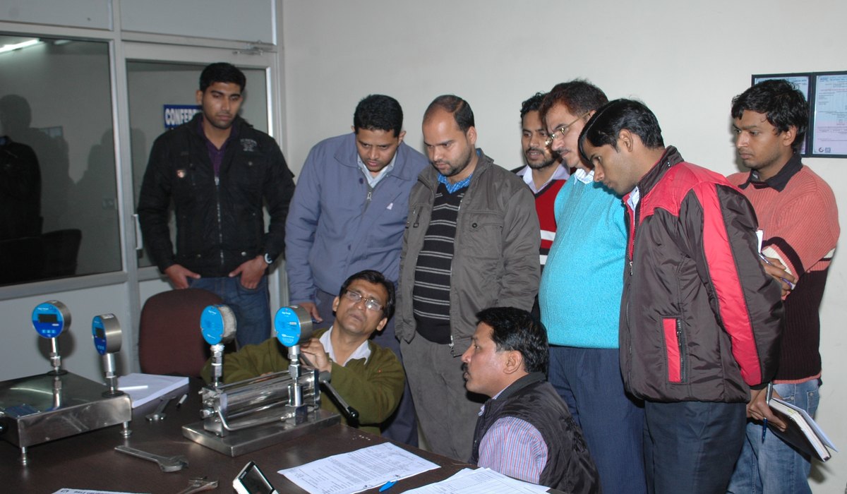 Engineers around a laboratory bench during a metrology training session
